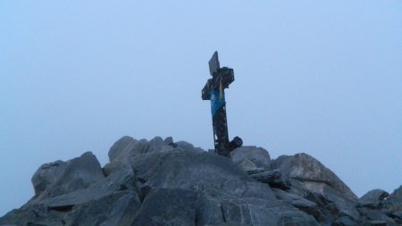 La Croix sommitale apparaît dans la grisaille de l’aube.