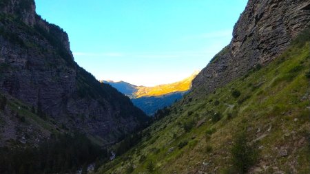 Dans le rétro : au loin le soleil embrase les alpages