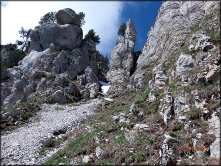 Au pied du couloir du Roc de Cognère.  Le passage se trouve entre les deux rochers derrière le petit névé.